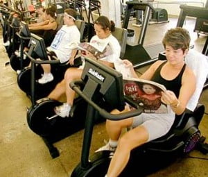 reading-newspaper-while-riding-stationary-bikes